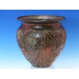 JOHN PEARSON, NEWLYN, A COPPER BOWL WORKED IN RELIEF WITH FLOWERS AGAINST A HAMMERED GROUND,