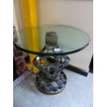 A GLASS TOPPED RETICULATED IRON TABLE ON A BRONZE CIRCULAR FOOT. Dia. 58 x H 60cms.