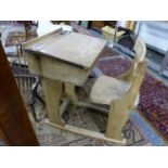 TWO OAK SCHOOL DESKS, ONE WITH THE CHAIR FIXED BEHIND THE WRITING SURFACE HINGED OVER A COMPARTMENT