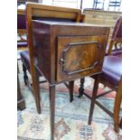 AN ANTIQUE MAHOGANY BEDSIDE CUPBOARD, THE CROSS BANDED TOP OVER A CUPBOARD AND TAPERING LEGS OF SQUA