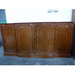 A 19th C. CROSS BANDED MAHOGANY BREAKFRONT BOOKCASE ON PLINTH FOOT. W 215 x D 46 x H 108cms.