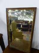 A RECTANGULAR BEVELLED GLASS MIRROR WITHIN A GEORGE III GILT FOLIATE BEZEL AND MAHOGANY FRAME. 65.