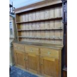 AN ANTIQUE PINE DRESSER, THE ENCLOSED THREE SHELF BACK RECESSED ABOVE THREE DRAWERS AND THREE CUPBOA