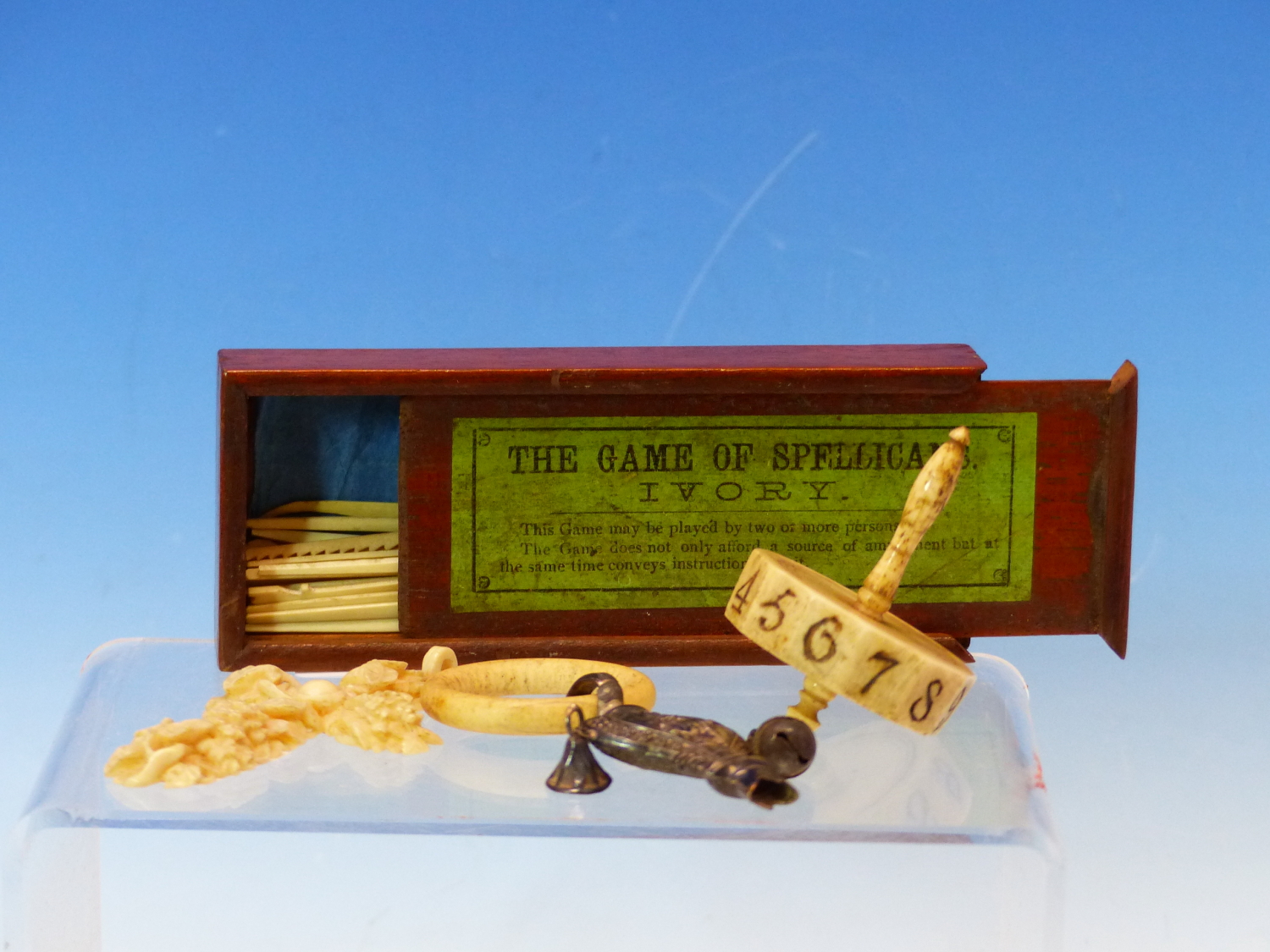 A BOXED GAME OF IVORY SPELLICANS, A BONE SPINNING DIE, A FLORAL CARVED IVORY CROSS PENDANT AND A