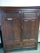 A 18th C. OAK WARDROBE/HALL CABINET, THE DOORS TWIN PANELLED BELOW HEART AND LEAF CARVED BANDS.