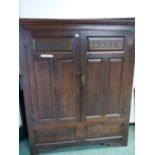 A 18th C. OAK WARDROBE/HALL CABINET, THE DOORS TWIN PANELLED BELOW HEART AND LEAF CARVED BANDS.