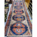 AN ANTIQUE PERSIAN TRIBAL RUNNER, 479 x 129cms