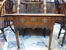 AN 18th C. OAK SIDE TABLE, THE CENTRAL DRAWER ABOVE A WAVY APRON RUNNING UP BELOW FLANKING DRAWERS