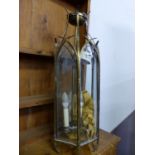 A GLAZED BRASS HEXAGONAL THREE LIGHT LANTERN, EACH GLASS PANEL WITH GOTHIC ARCHED TOP. H 79cms.
