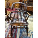 AN ANTIQUE LOW BACKED WINDSOR CHAIR WITH A ROUND ARCH SEVEN STICK BACK TOGETHER WITH A WHEEL BACKED
