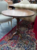 A GEORGIAN MAHOGANY TRIPOD TABLE, THE DISHED CIRCULAR TOP ON GUN BARREL COLUMN ABOVE CLUB FEET. Dia.