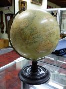 A PHILIPS 12 INCH TERRESTIAL GLOBE SPINNING WITHIN A CHROME ARC ON AN EBONISED WOOD PLINTH