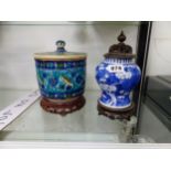 AN ORIENTAL BLUE AND WHITE JAR WITH WOODEN PIERCED COVER AND STAND, TOGETHER WITH AN IZNIK STYLE