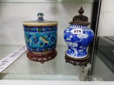AN ORIENTAL BLUE AND WHITE JAR WITH WOODEN PIERCED COVER AND STAND, TOGETHER WITH AN IZNIK STYLE