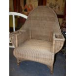 A DRYAD BASKET WORK ARMCHAIR, THE ROUND ARCHED BACK CENTRED BY A DIAMOND, THE ARMS WITH COMPARTMENTS