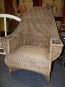 A DRYAD BASKET WORK ARMCHAIR, THE ROUND ARCHED BACK CENTRED BY A DIAMOND, THE ARMS WITH COMPARTMENTS