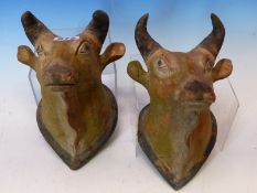 A PAIR OF INDIAN PAINTED TERRACOTTA WALL HANGING HEADS OF COWS. H 23cms.