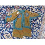 AN ISLAMIC TALISMANIC BROWN TUNIC PAINTED WITH BLUE EDGING AND ORANGE DETAILS ABOUT INSCRIPTIONS