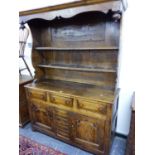 A 19thC. OAK DRESSER, A HOOD RAISED OVER THE ENCLOSED TWO SHELF BACK, THE BASE WITH THREE DRAWERS