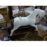 A WHITE PAINTED ROCKING HORSE ON TRESTLE BASE, ITS TAIL OF REAL HAIR