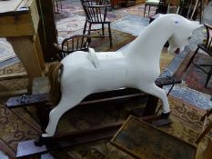 A WHITE PAINTED ROCKING HORSE ON TRESTLE BASE, ITS TAIL OF REAL HAIR