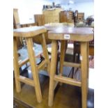 A PAIR OF VINTAGE STOOLS WITH TOOLED LEATHER TOPS.