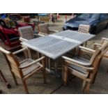 A GOOD QUALITY EXTENDING GARDEN TABLE AND TEN CHAIRS AND CUSHIONS. H. 76cms W. 110cms L. 190cms
