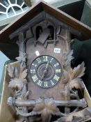 A BLACK FOREST STAINED PINE CUCKOO CLOCK, THE CHALET HOUSING CRESTED BY A STAGS HEAD FLANKED BY VINE