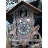 A BLACK FOREST STAINED PINE CUCKOO CLOCK, THE CHALET HOUSING CRESTED BY A STAGS HEAD FLANKED BY VINE