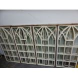 ELEVEN GLAZED WOODEN WINDOW FRAMES, EACH WITH SQUARES BELOW A TRIPLE GOTHIC ARCHED TOP. 101 x 44.