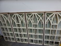 ELEVEN GLAZED WOODEN WINDOW FRAMES, EACH WITH SQUARES BELOW A TRIPLE GOTHIC ARCHED TOP. 101 x 44.