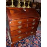 A GEORGE III MAHOGANY BUREAU, THE FALL OPENING ONTO PIGEON HOLES, DRAWERS AND A SLIDE CONCEALED