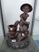 A CARVED WOOD FISHERMAN, A PESTLE AND MORTAR TOGETHER WITH A CHINESE HARD WOOD STAND