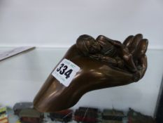 A GENESIS 2000 LIMITED EDITION BRONZED FIGURE OF A CHILD ASLEEP IN A HAND