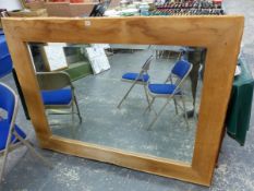 A RECTANGULAR BEVELLED GLASS MIRROR IN AN OAK FRAME WITH BARKED EDGES. 119 x 159cms.