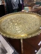 A BRASS DISH WORKED WITH FRUITING VINES AND SUPPORTED ON A FOLDING BASE TOGETHER WITH A CANED BACK