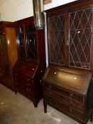 AN EDWARDIAN MAHOGANY BUREAU BOOKCASE AND A LATER OAK EXAMPLE.