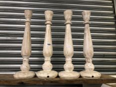 A SET OF FOUR PAINTED WOOD CANDLE STANDS.