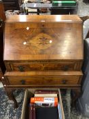 A 20th C. WALNUT BUREAU, THE FALL OPENING TO PUSH OUT THE LOPERS FLANKING A DRAWER ABOVE ANOTHER AND