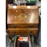 A 20th C. WALNUT BUREAU, THE FALL OPENING TO PUSH OUT THE LOPERS FLANKING A DRAWER ABOVE ANOTHER AND