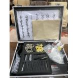 A TATTOO GUN IN CARRY CASE WITH ACCESSORIES AND INKS.