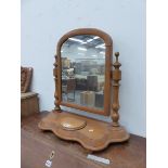 A PINE DRESSING TABLE MIRROR, THE ROUNDED TOPPED RECTANGULAR PLATE BETWEEN TURNED COLUMNS AND WAVY