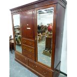 A MAHOGANY COMPACTUM WITH TWO MIRRORED DOORS OVER DRAWERS FLANKING A CUPBOARD AND THREE SHORT