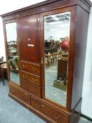 A MAHOGANY COMPACTUM WITH TWO MIRRORED DOORS OVER DRAWERS FLANKING A CUPBOARD AND THREE SHORT