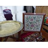 AN EASTERN BRASS DISH TOPPED FOLDING TABLE, A RED BORDERED VELVET FLORAL PANEL AND AN OAK FRAMED