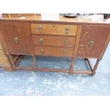 A 20th C. OAK SIDEBOARD WITH THE CENTRAL THREE DRAWERS FLANKED BY CUPBOARDS, THE FOUR BALUSTER FRONT