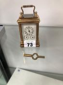 A MINIATURE BRASS CASED CARRIAGE CLOCK WITH TRIPLE DIAL.