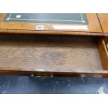 AN EDWARDIAN OAK DESK, THE LEATHER INSET TOP SLIDING OUT OVER A DRAWER, THE SQUARE LEGS TAPERING