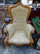 A VICTORIAN STYLE BEECH SHOW FRAME ARMCHAIR THE S-SCROLL BACK CENTRED BY A FLOWER ABOVE BUTTONED BEI