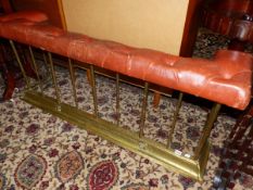 AN ANTIQUE BRASS AND LEATHER UPHOLSTERED CLUB FENDER.